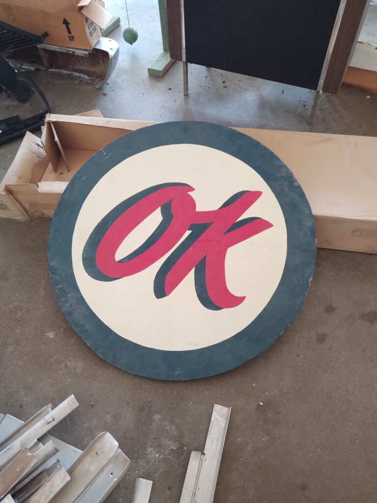 Vintage round hand-painted OK advertising sign