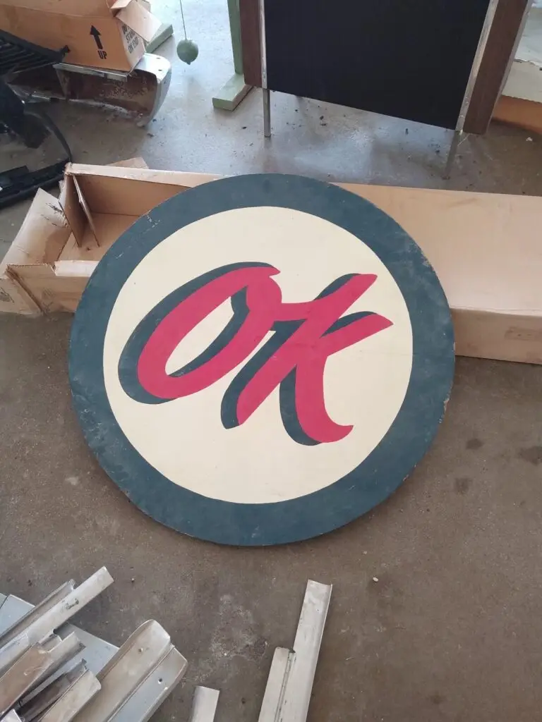 Vintage round hand-painted OK advertising sign